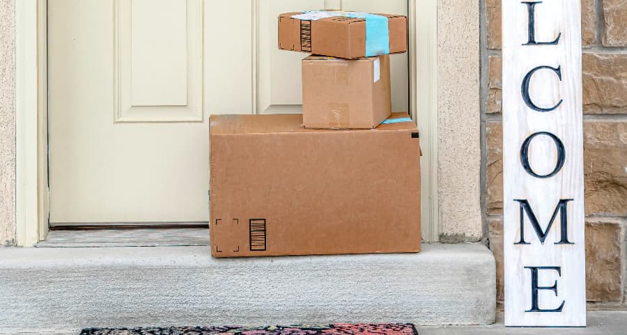 Packages on the doorstep of a home with a welcome sign in Indianapolis